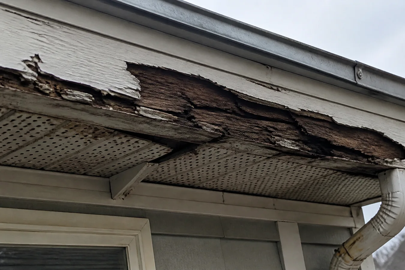 Illustrated peeling fascia and damaged soffit at a roof edge.