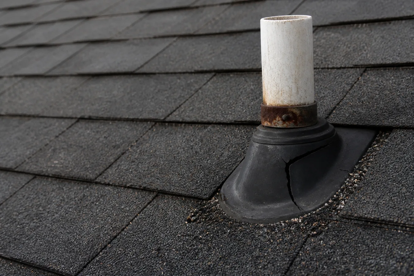 Illustrated plumbing vent boot flashing on an asphalt roof.